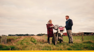 Farmers chatting over a motorbike in paddock